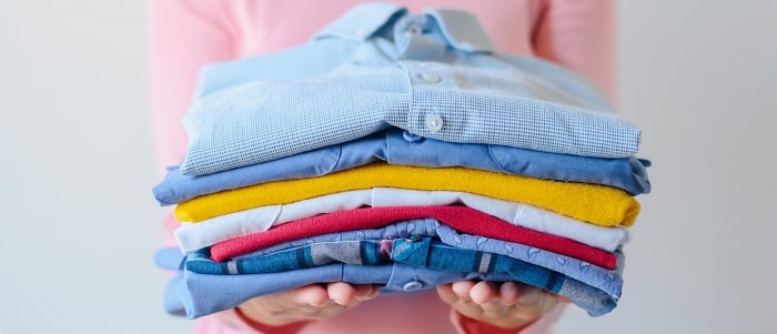Girl Holding Pile Of Washed And Ironed Clothes Min